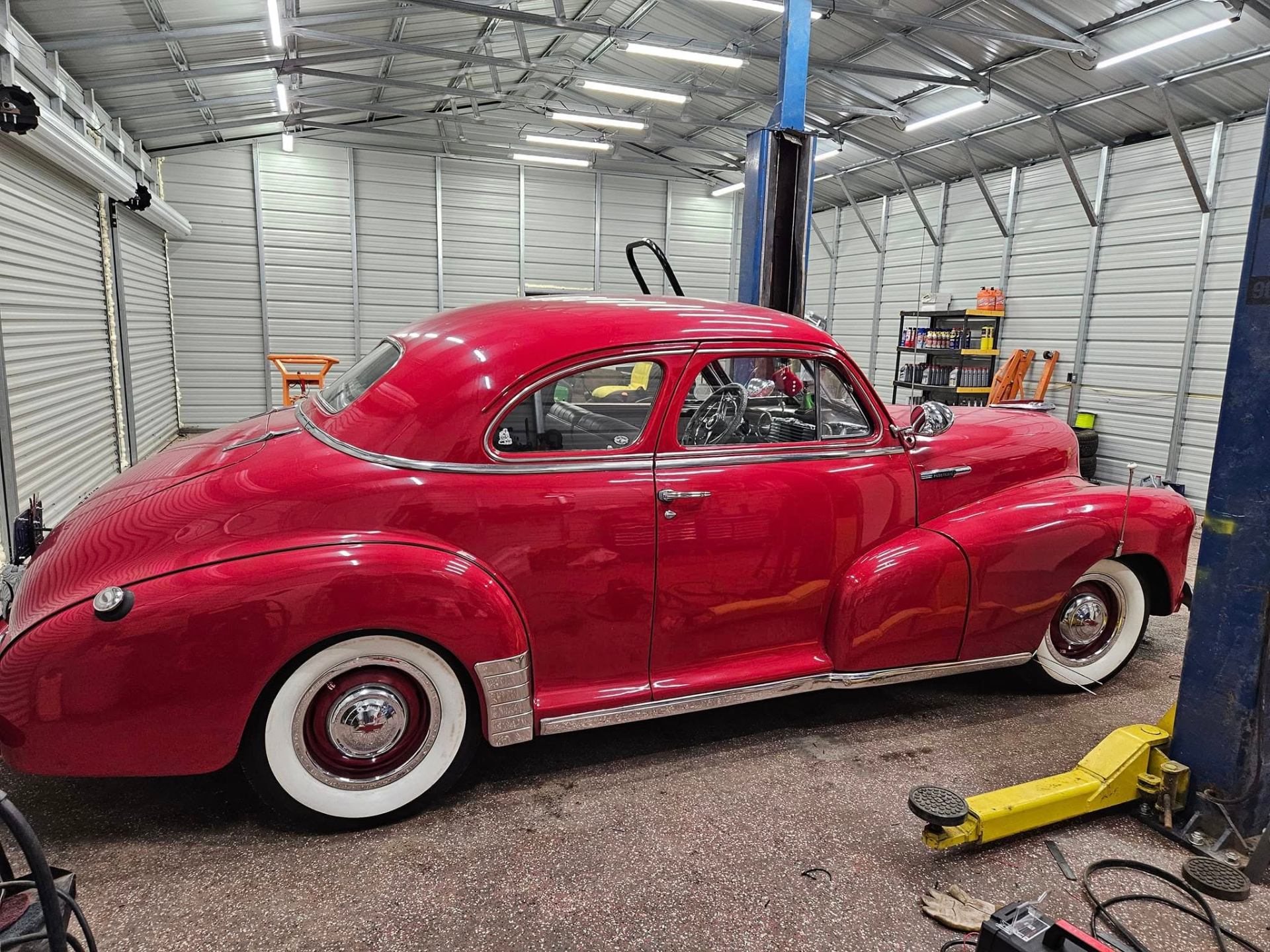 Classic red coupe restoration on the lift